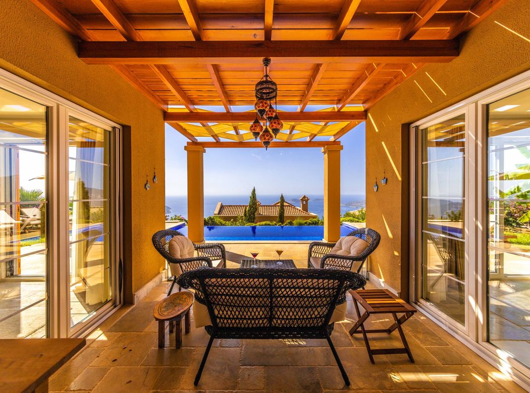 A shaded terrace looking out to the pool and the sea