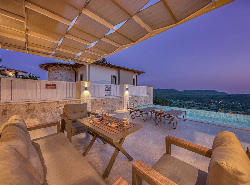 A terrace set for dinner above the pool